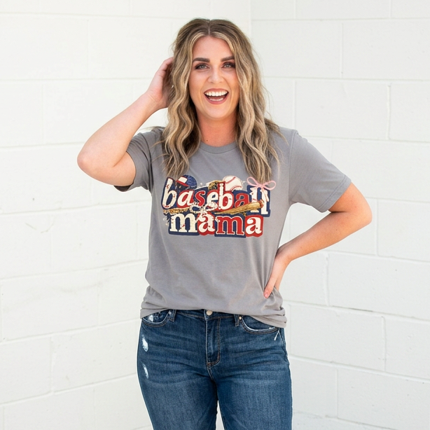 Woman wearing a 'baseball mama' t-shirt and jeans against a white brick wall.