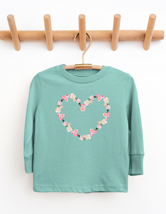 Teal long-sleeve shirt with a floral heart design on a wooden hanger against a white background