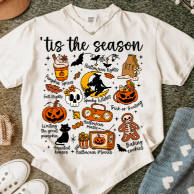 White t-shirt with Halloween-themed graphics and text on a textured surface.