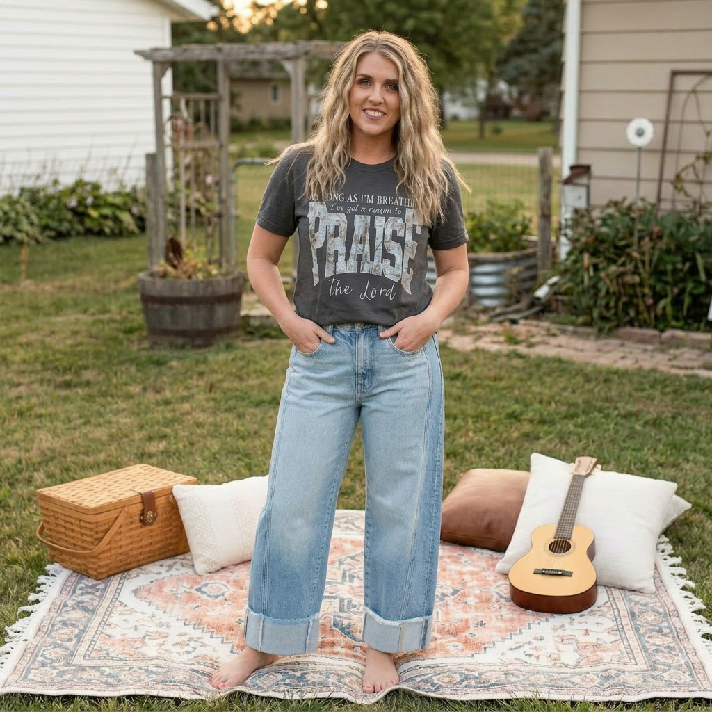 Woman standing on a blanket with pillows and a guitar in a backyard setting