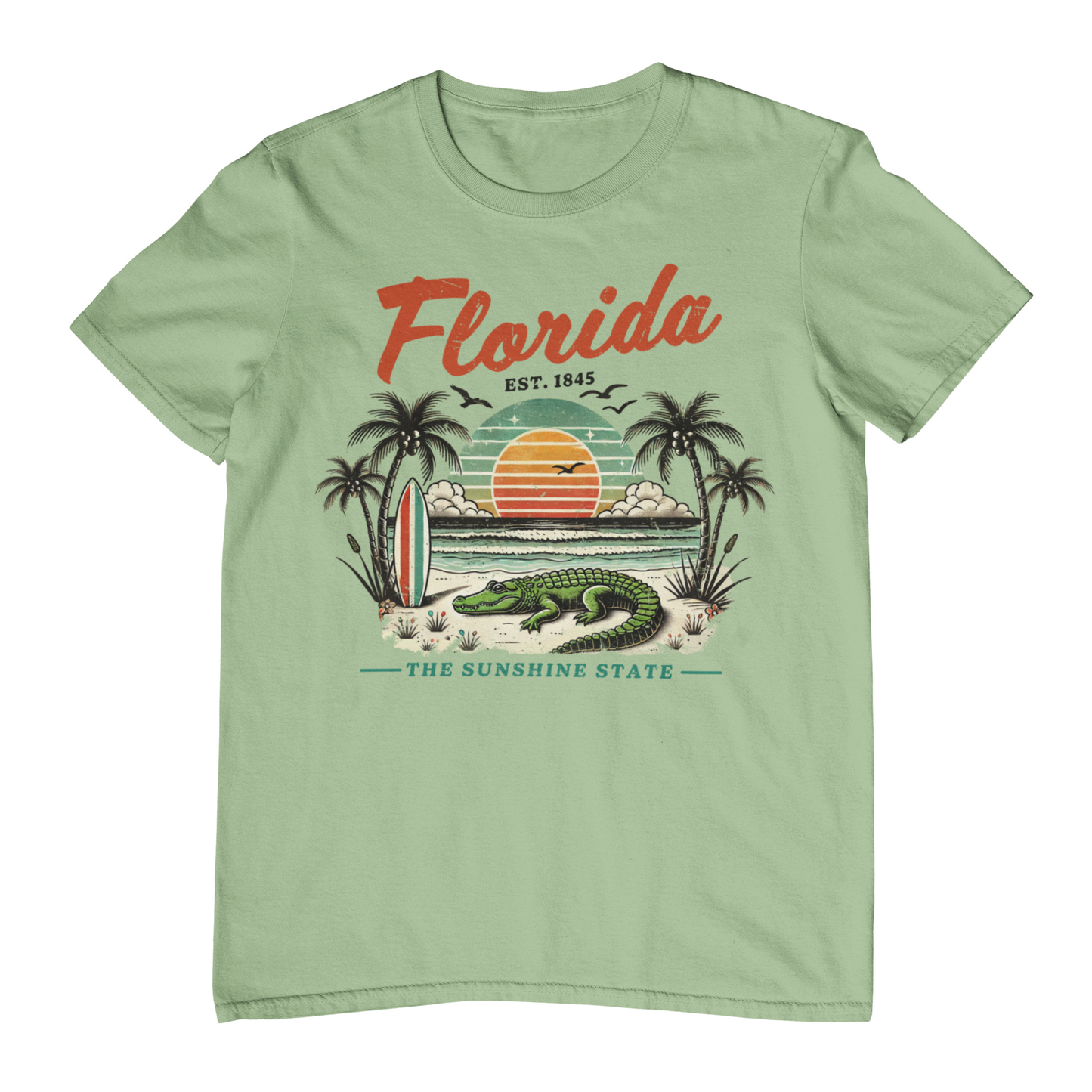 Light green t-shirt with Florida graphic design featuring an alligator, palm trees, and sunset.