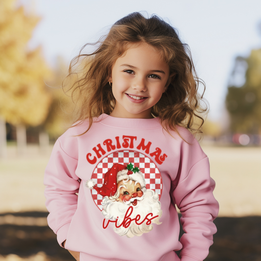 Child wearing a pink sweatshirt with Christmas design outdoors