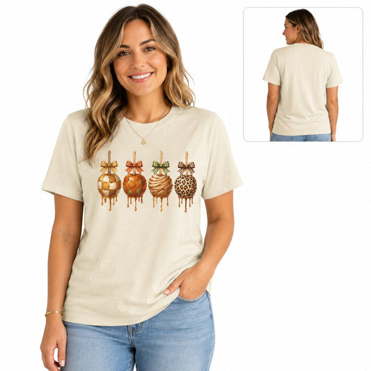 Tea-Shirt Shoppe cream graphic tee featuring four decorated caramel apples with plaid bows on a smiling woman