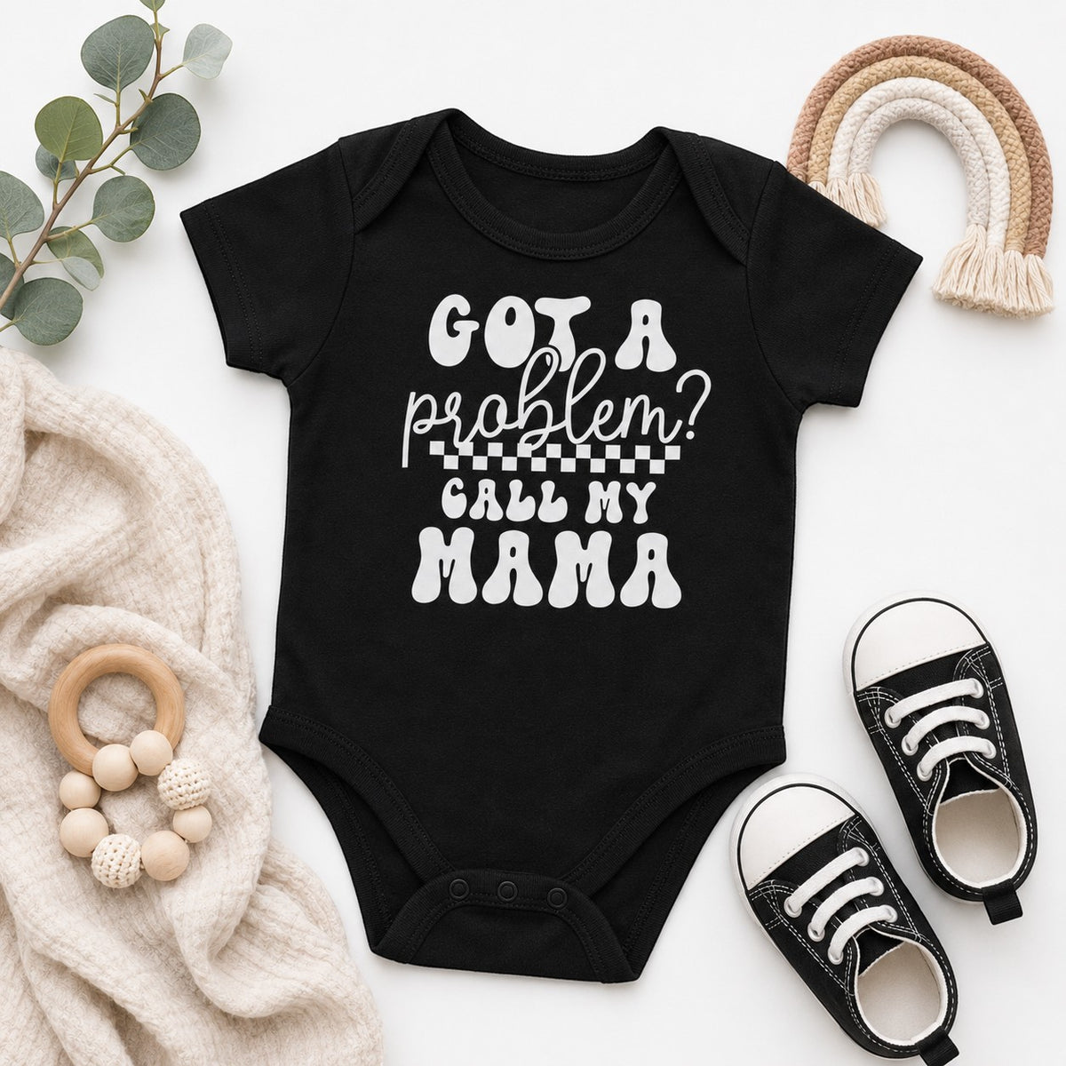 Tea Shirt Shoppe Wholesale black infant bodysuit with white Got a Problem Call My Mama text and checkered detail.