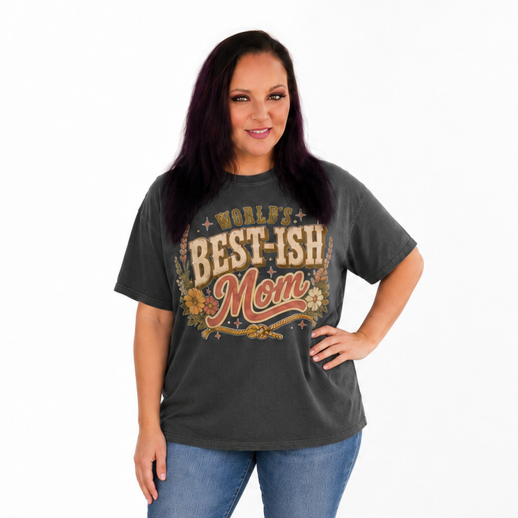 Tea Shirt Shoppe Wholesale charcoal graphic tee with vintage-inspired Worlds Best-Ish Mom print on a smiling woman.