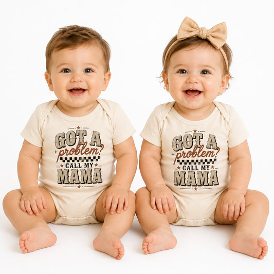 Two babies wearing Tea Shirt Shoppe Wholesale cream infant bodysuits with Got a Problem Call My Mama graphic print.