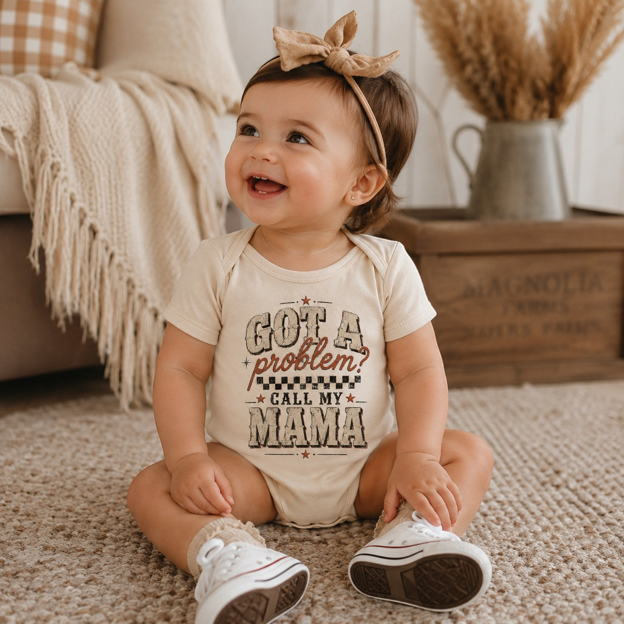 Tea Shirt Shoppe Wholesale cream infant bodysuit with Got a Problem Call My Mama graphic worn by a smiling baby