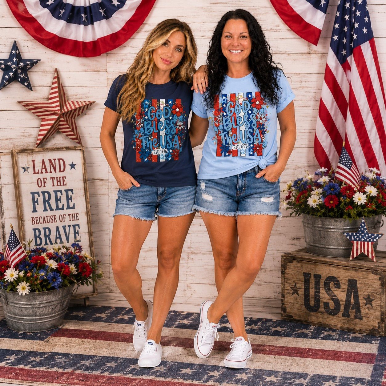 Tea Shirt Shoppe Wholesale navy and light blue graphic tees with "God Bless The USA" text and floral design.
