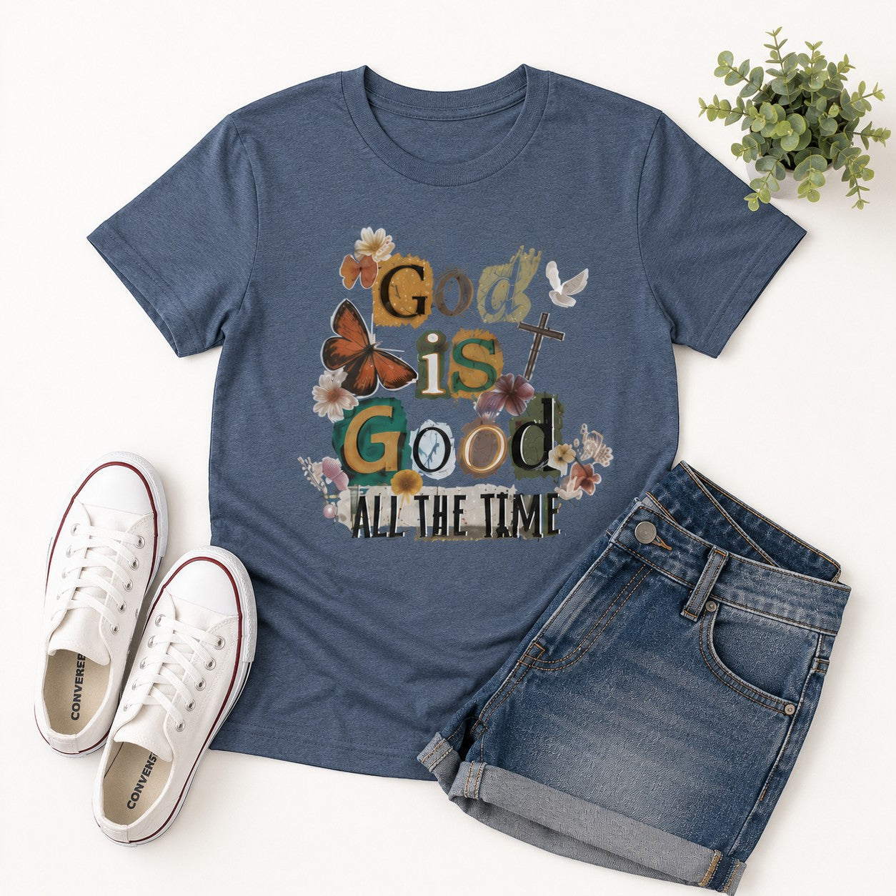 Tea Shirt Shoppe Wholesale dusty blue cotton graphic t-shirt with butterflies, flowers, and God Is Good text.