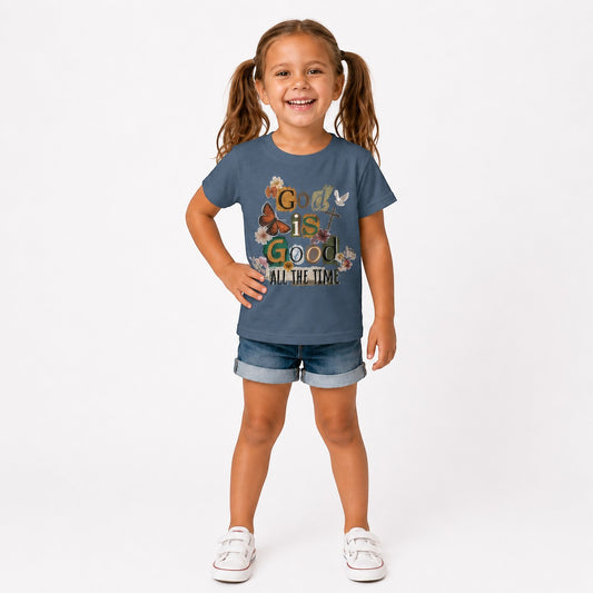 A smiling girl wears a dusty blue Tea Shirt Shoppe Wholesale cotton graphic tee with floral and faith-based designs.