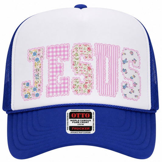 Tea Shirt Shoppe Wholesale trucker hat with white front panel featuring "JESUS" in patchwork letters, royal blue brim and mesh back.