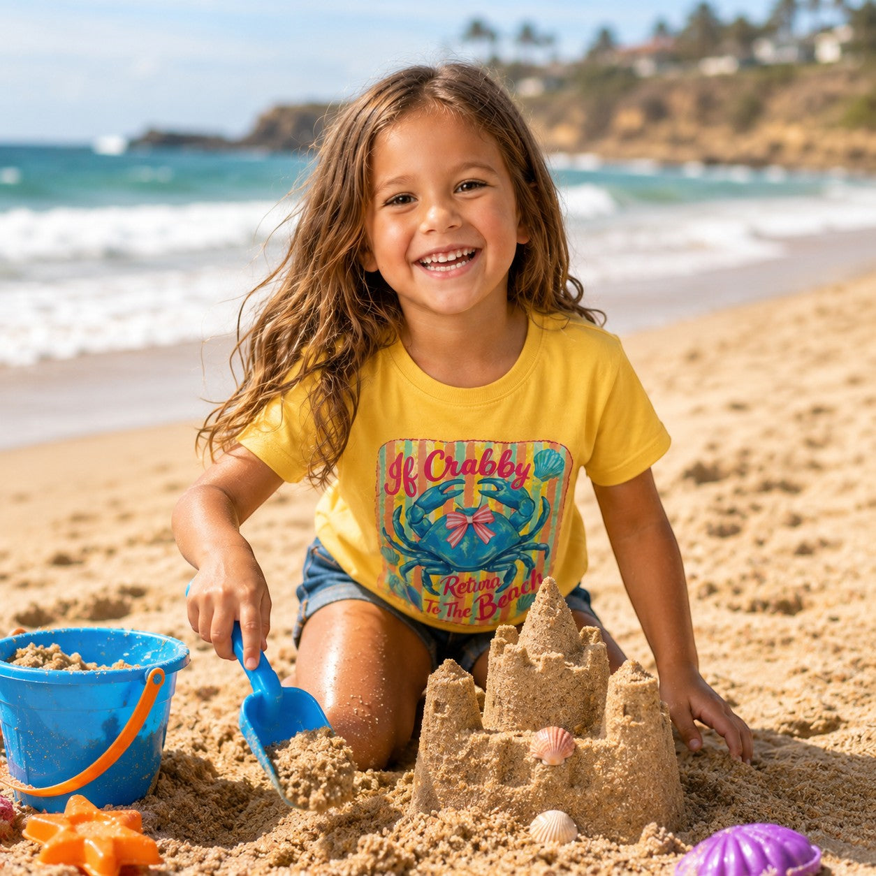 Tea Shirt Shoppe Wholesale yellow kids t-shirt with blue crab graphic and pink bow, beach scene graphic.
