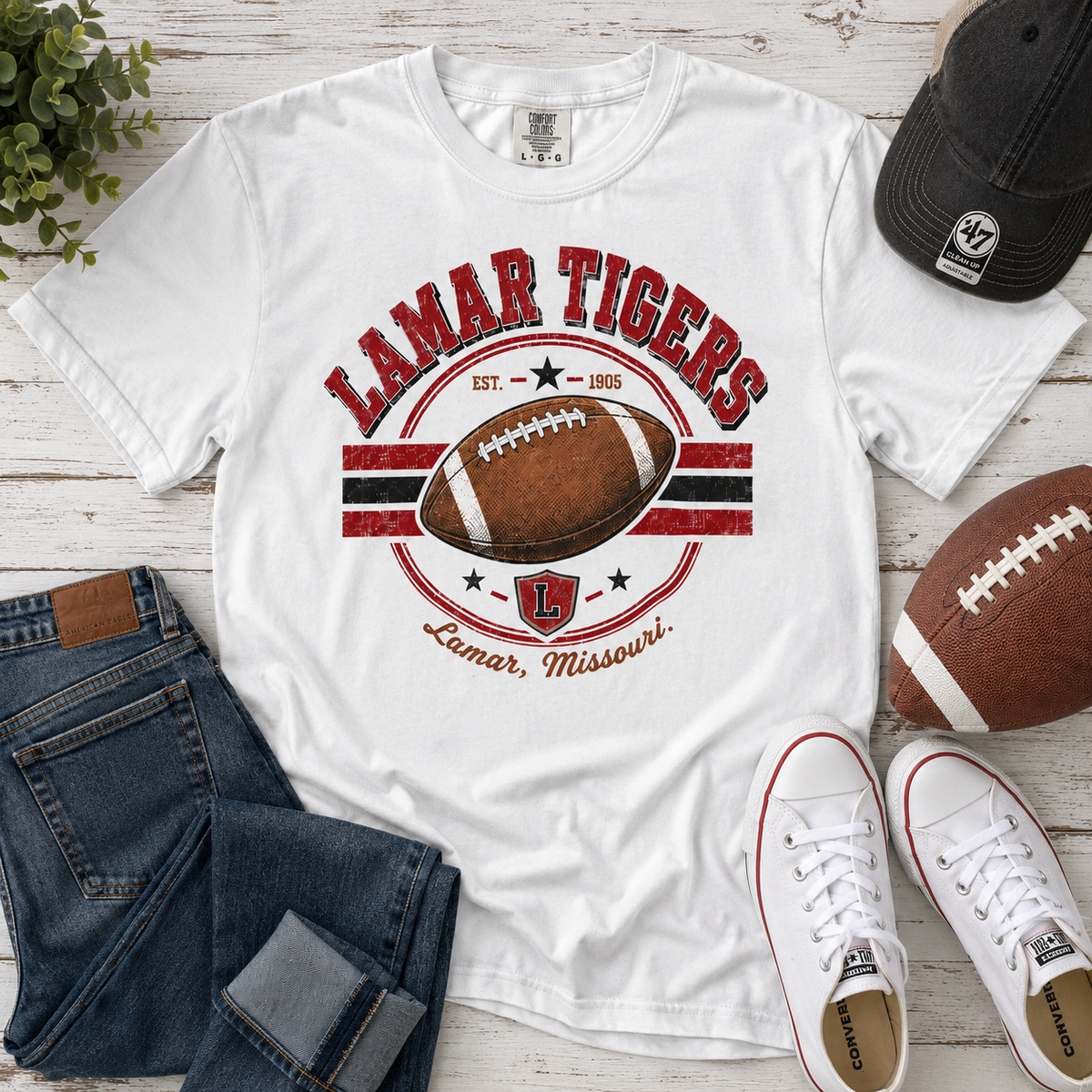 Tea Shirt Shoppe Wholesale white Comfort Colors graphic tee featuring a Lamar Tigers football design on wood table