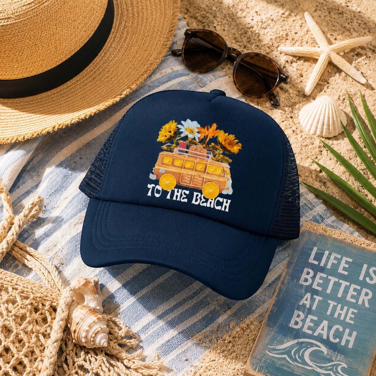 Tea Shirt Shoppe Wholesale navy blue trucker hat with embroidered "To The Beach" text and a vintage van with flowers.