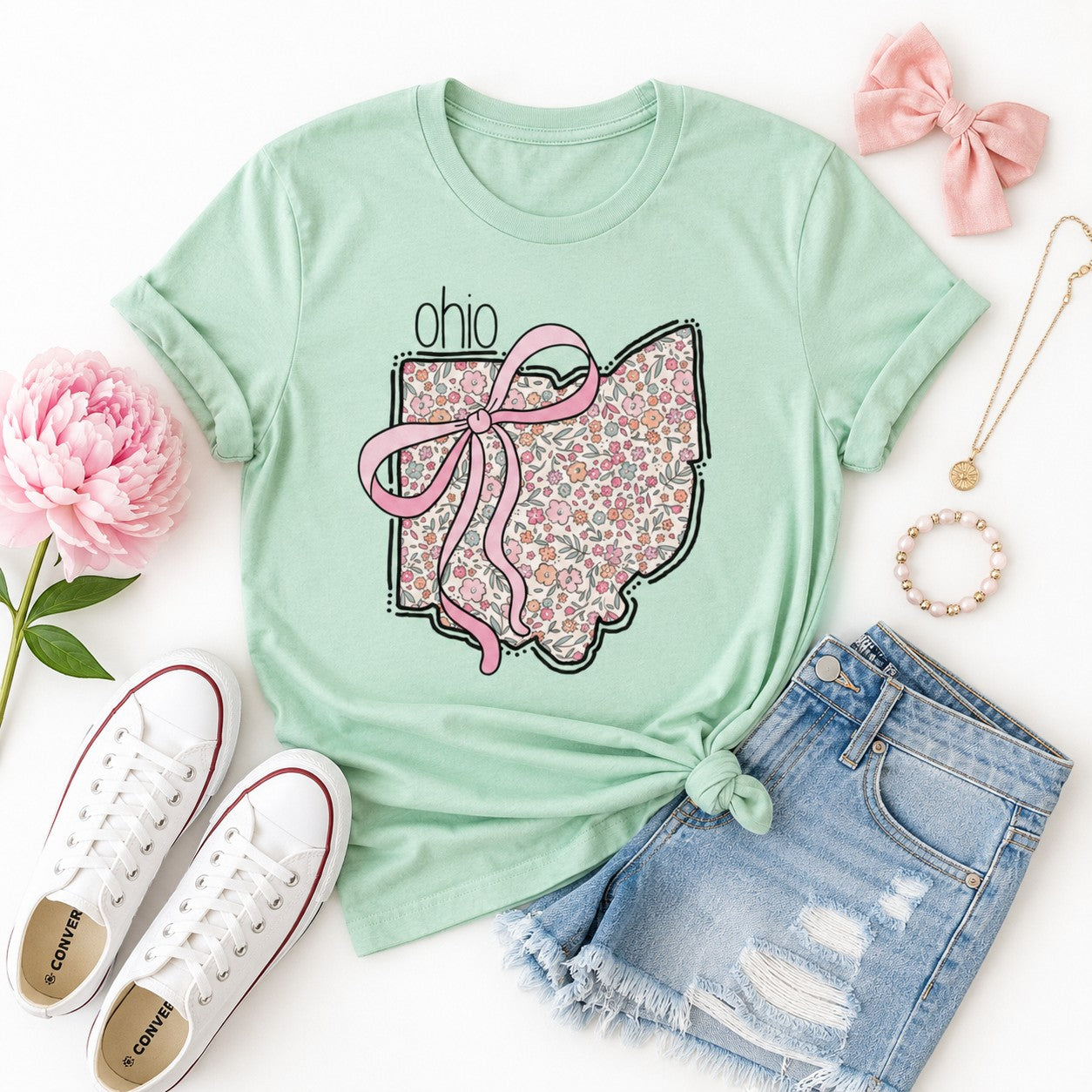 Tea Shirt Shoppe Wholesale mint green cotton graphic tee with floral Ohio state outline and pink bow design.