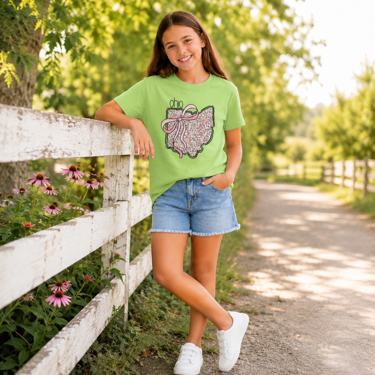 Tea Shirt Shoppe Wholesale light green t-shirt with Ohio floral state outline and pink bow graphic on a young girl.