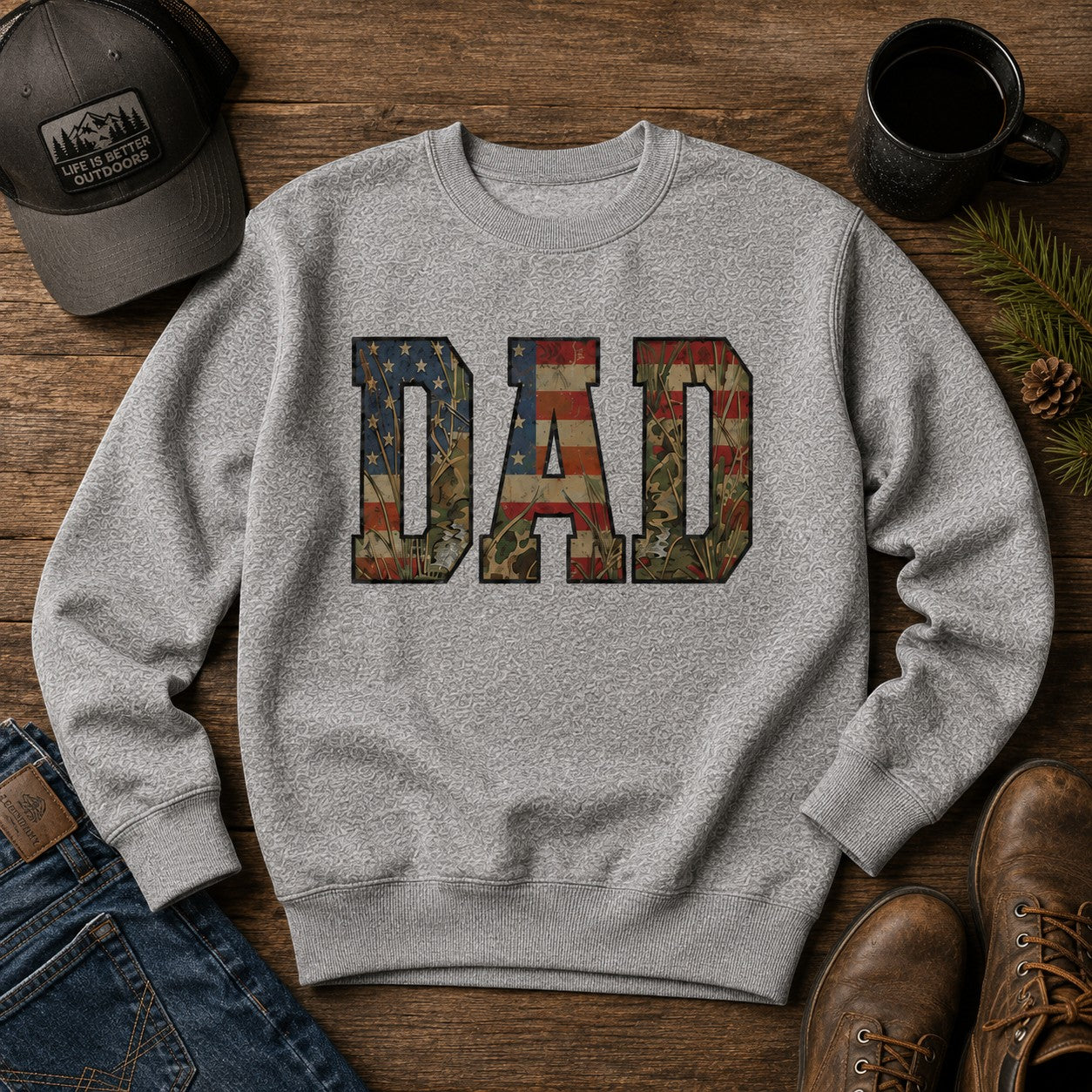 Tea Shirt Shoppe Wholesale heather grey crewneck sweatshirt with "DAD" graphic featuring American flag and camouflage patterns.