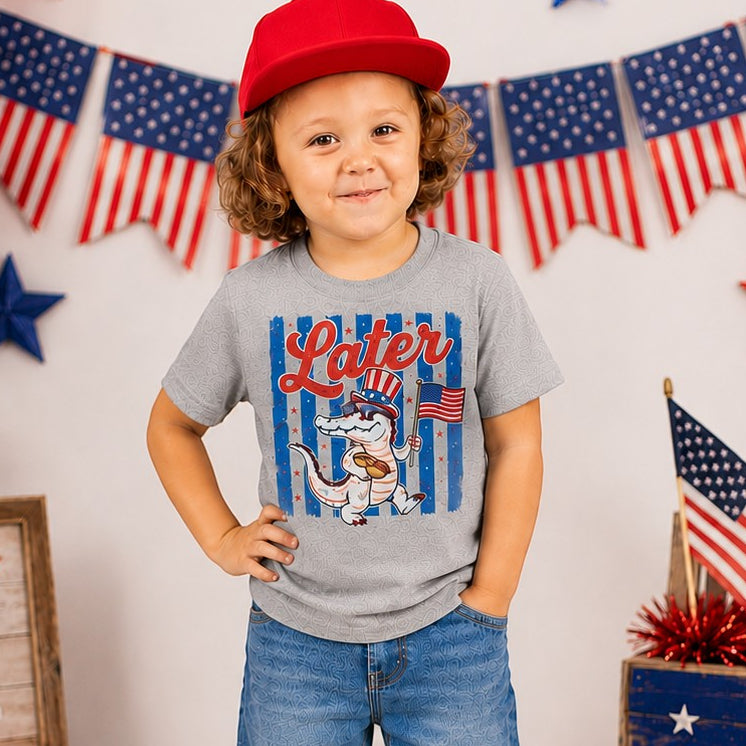 Tea Shirt Shoppe Wholesale heather grey youth graphic tee with alligator in Uncle Sam hat holding flag. Short sleeves, crew neck.