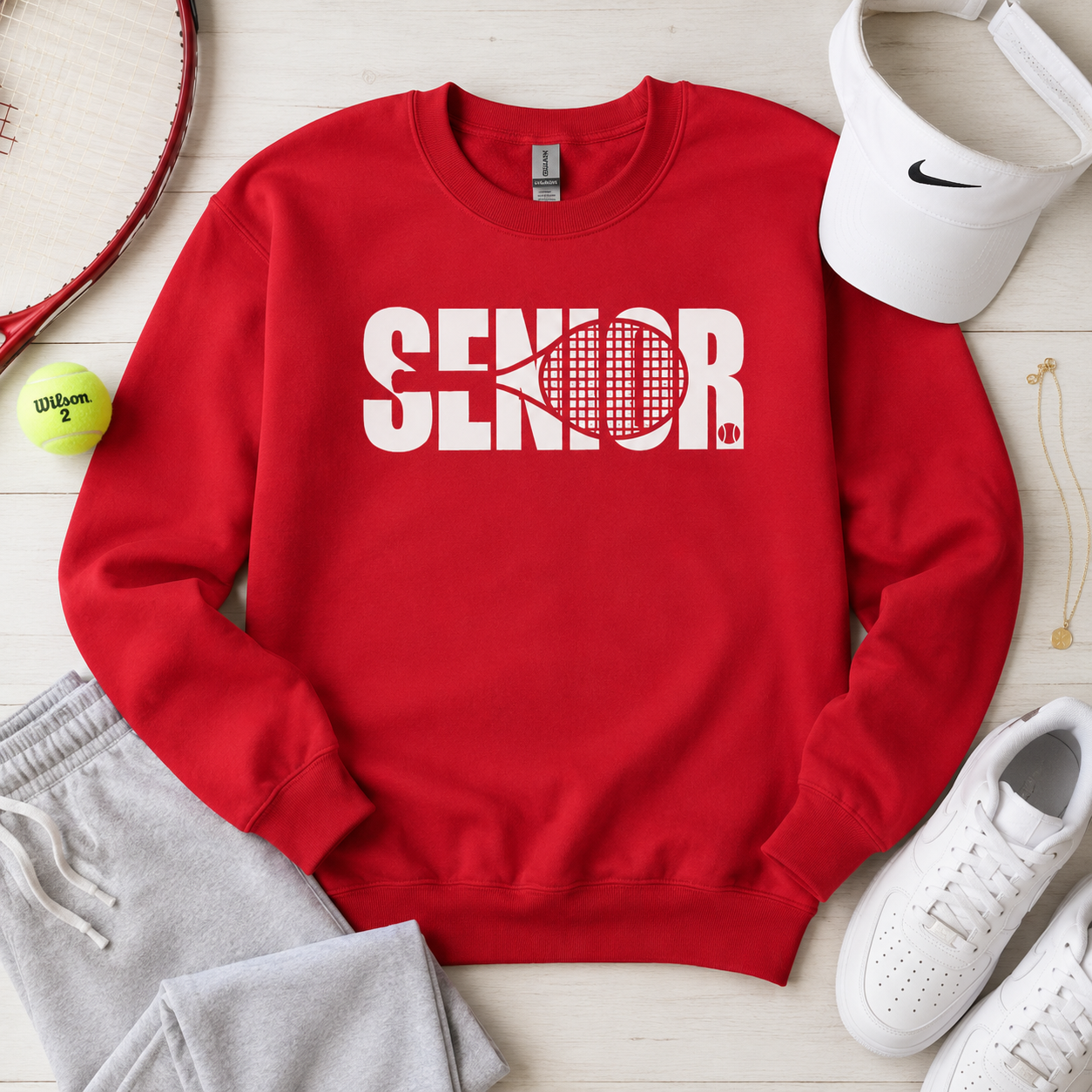 Tea Shirt Shoppe Wholesale red crewneck sweatshirt with white SENIOR graphic and tennis racket design on flat lay
