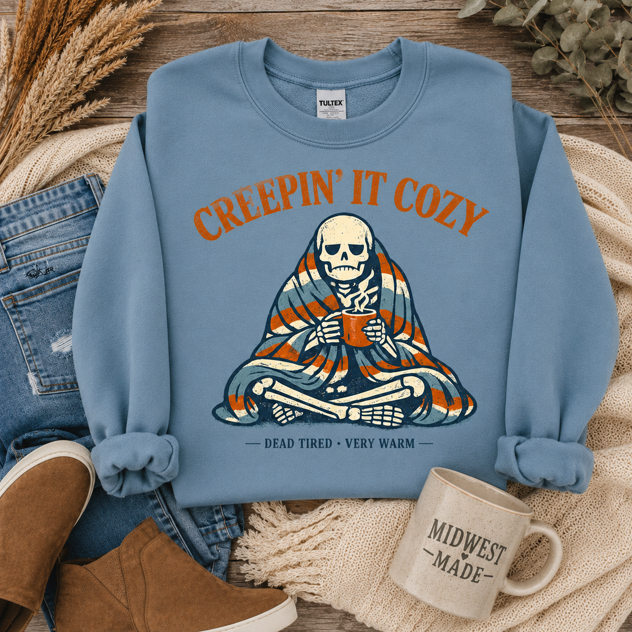Tea Shirt Shoppe Wholesale light slate graphic sweatshirt featuring a skeleton wrapped in a blanket with a mug