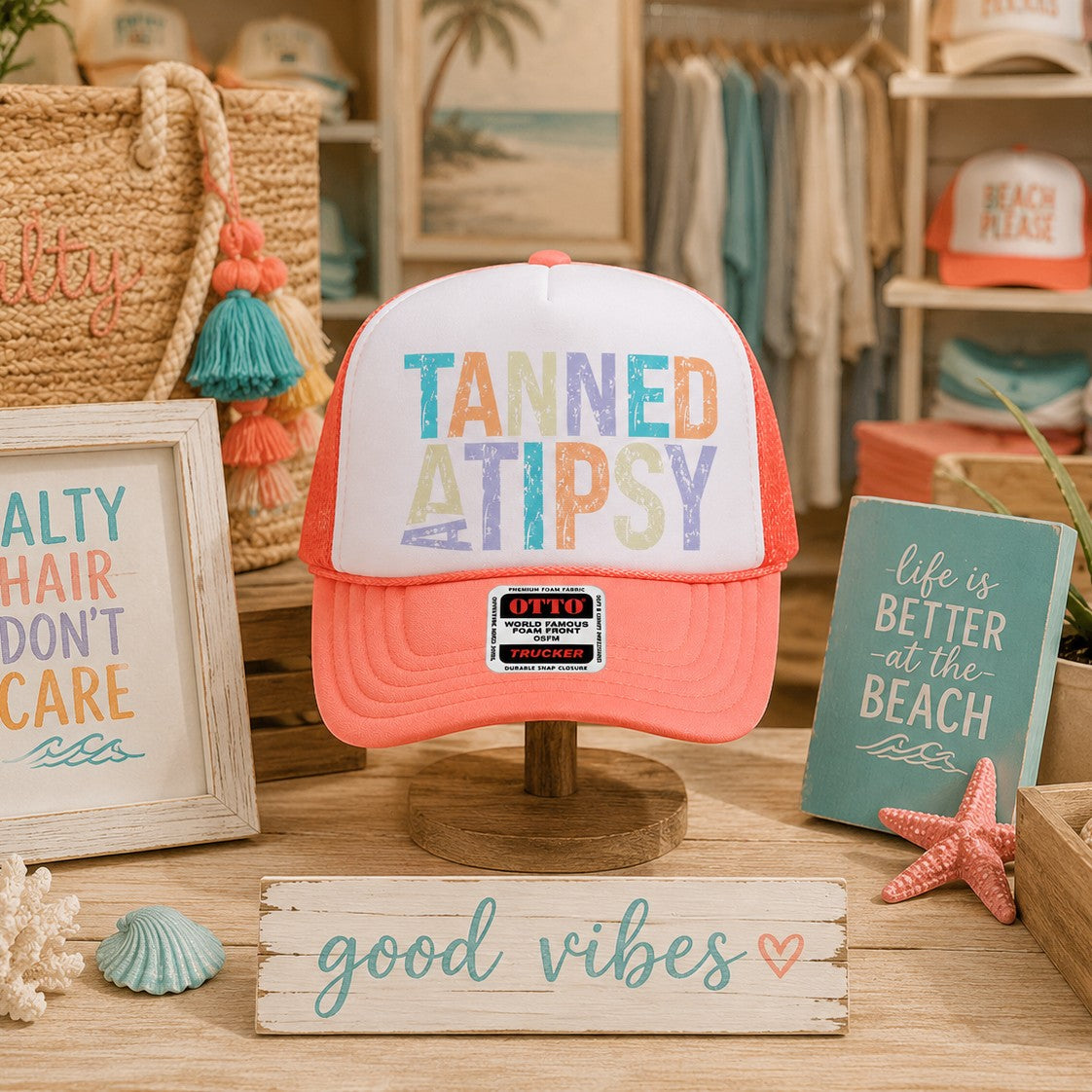 Tea Shirt Shoppe Wholesale Tanned And Tipsy trucker hat with white foam front, coral mesh back, and colorful text.