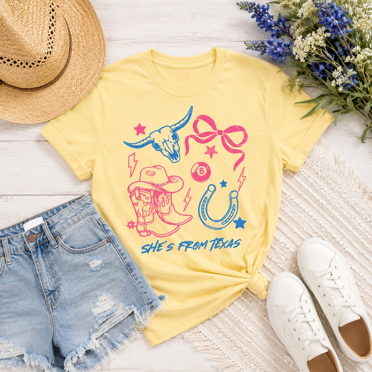 Tea Shirt Shoppe Wholesale buttery yellow cotton graphic tee with pink and blue western Texas-themed illustrations.