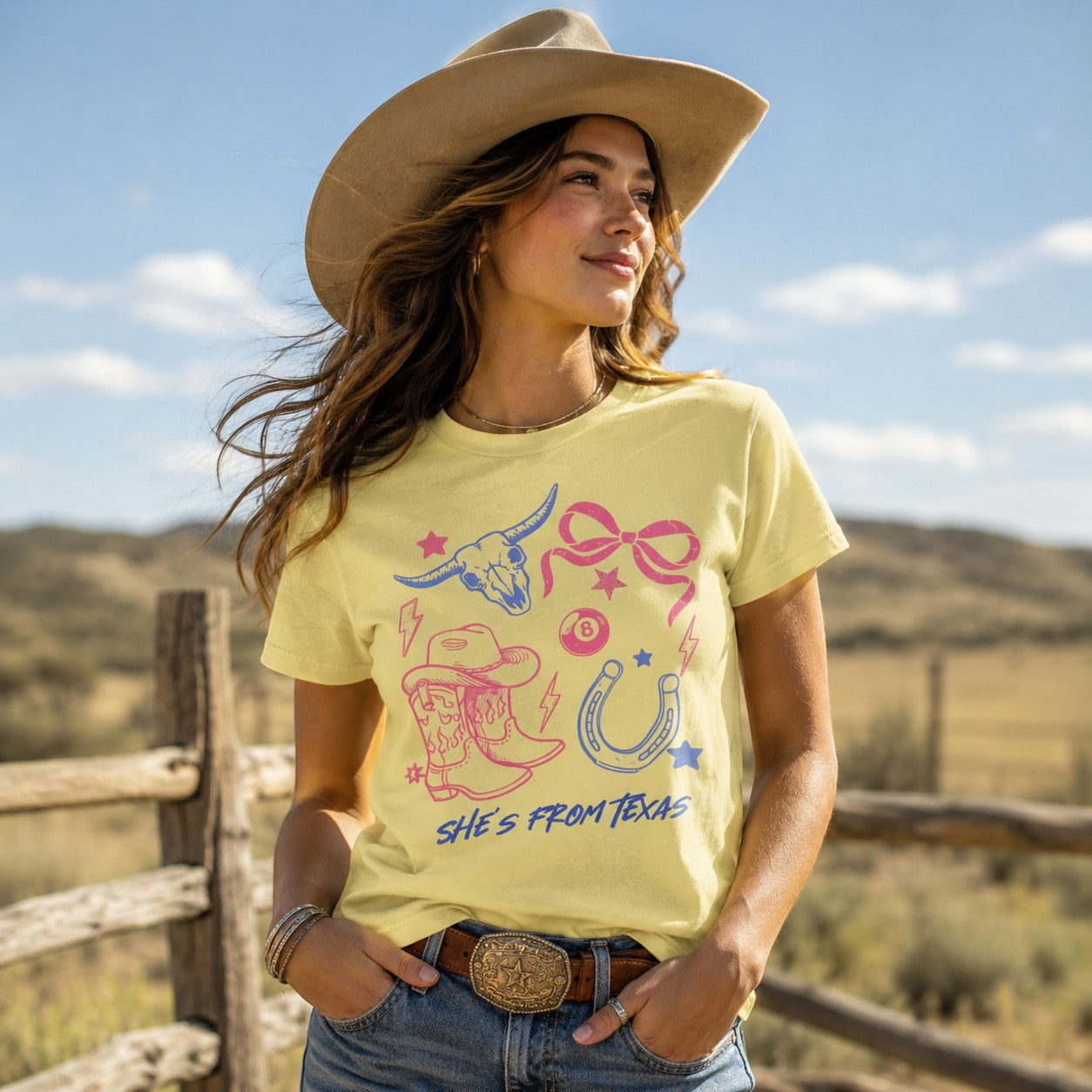 Woman wearing a Tea Shirt Shoppe Wholesale yellow graphic tee with western cowgirl motifs in pink and blue.